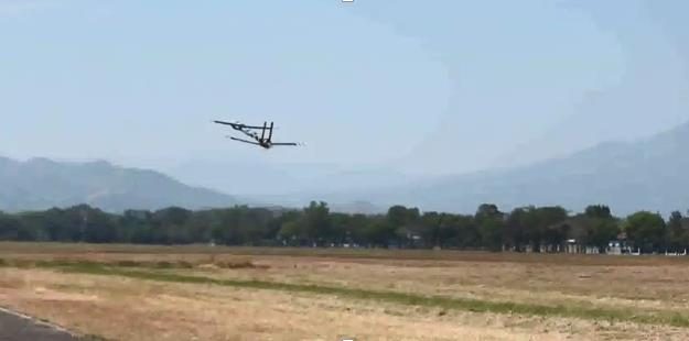 The tandem-wing UAV in flight over a field during flight testing